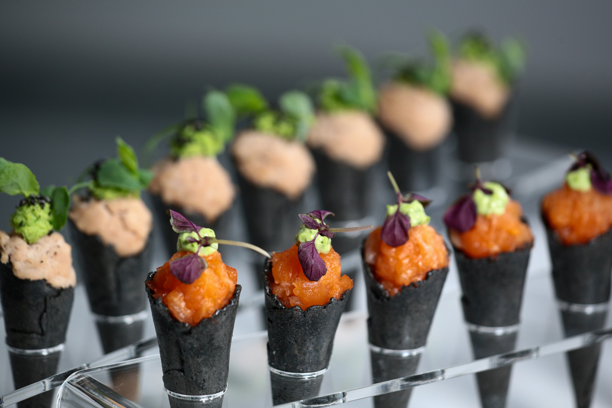 Nahaufnahme einer goldbraunen belgischen Waffel mit Puderzucker und frischen Beeren sowie Minzblättern, als süßer Nachtisch für ein Catering-Event