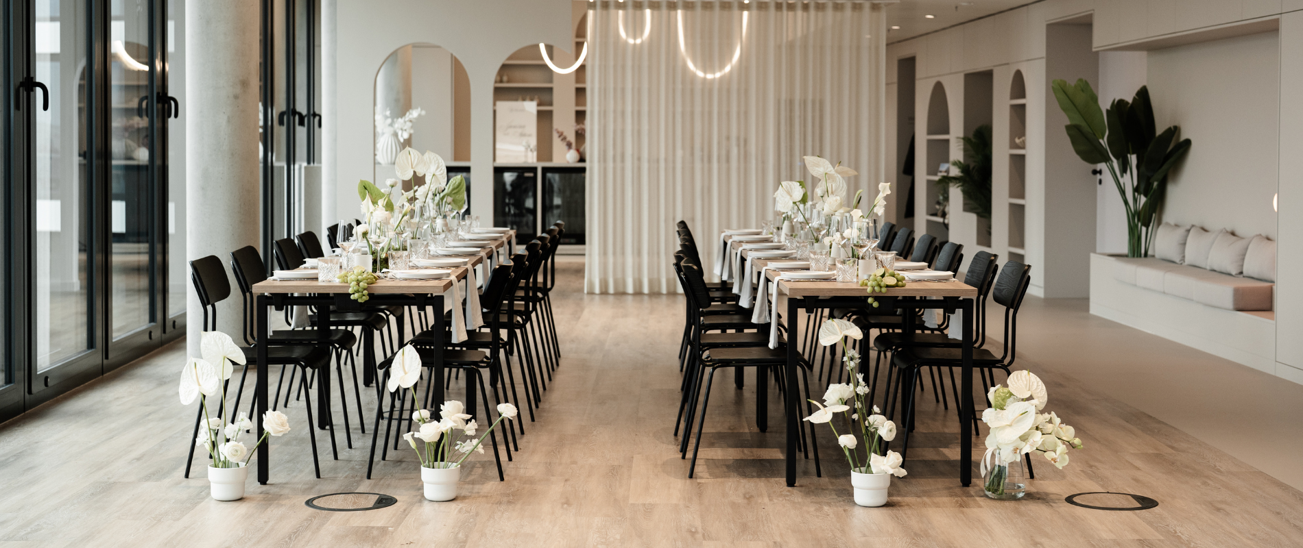 Place to be Eventlocation, rausm mit 2 gedeckten und dekorierten tischen, ganz viele Blumen und lichter