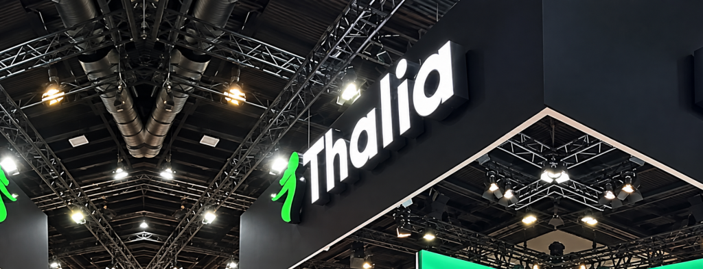 Beleuchteter Thalia-Messestand mit grünem Logo bei der Messe Frankfurt Catering und Eventpräsentation in dunkler Halle.