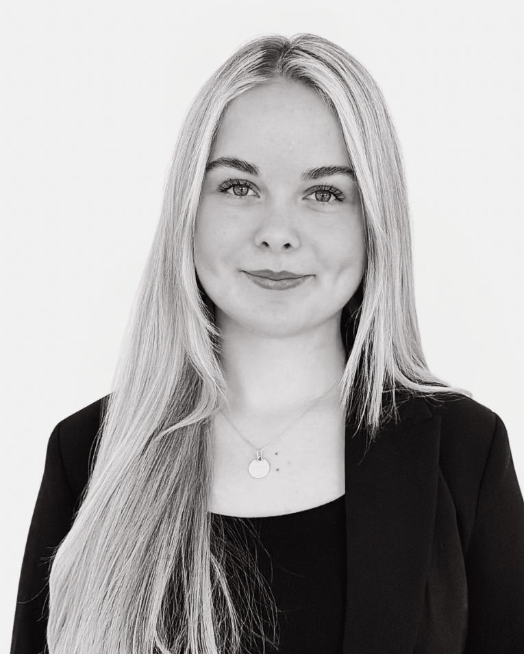 Lächelnde Mitarbeiterin der Premium Eventagentur Frankfurt im schwarzen Blazer mit langen blonden Haaren.
