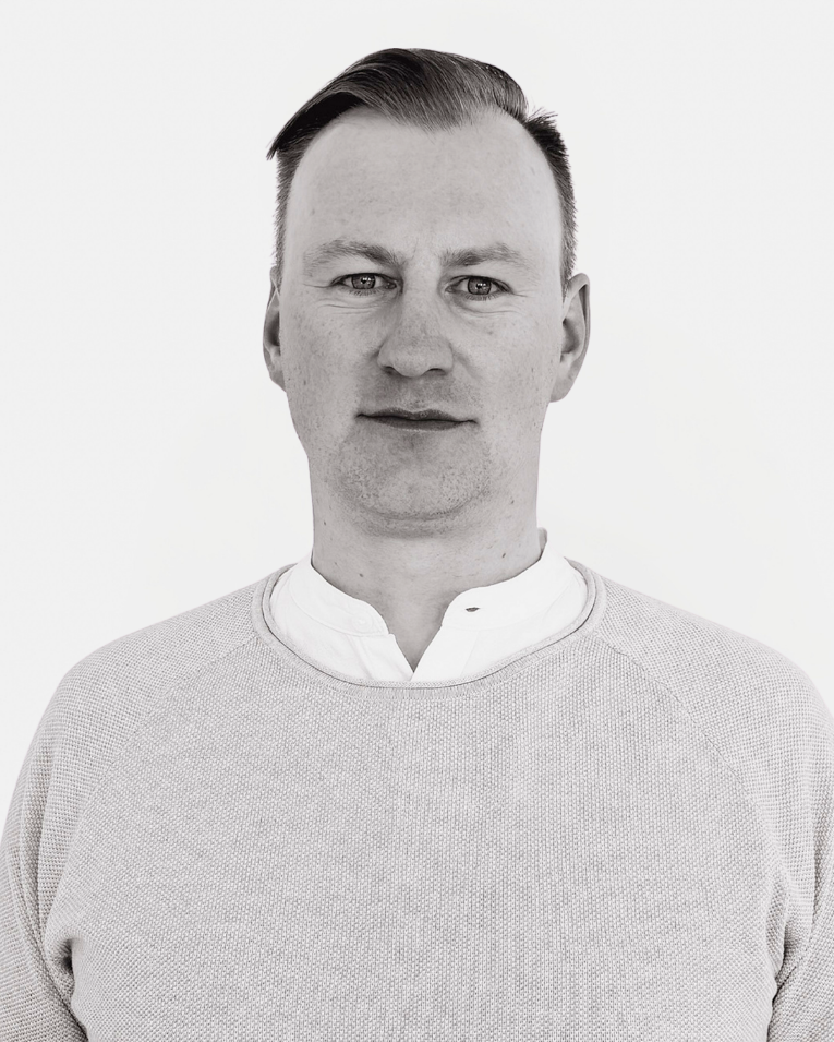 Mann im grauen Pullover – Teammitglied der Premium Eventagentur Frankfurt im professionellen Porträt.
