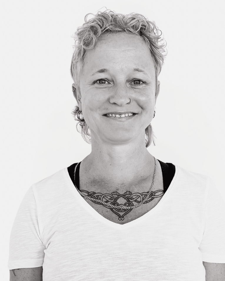Lächelnde Frau mit Kurzhaarfrisur und Brust-Tattoo vom Team der Veranstaltungsagentur Frankfurt