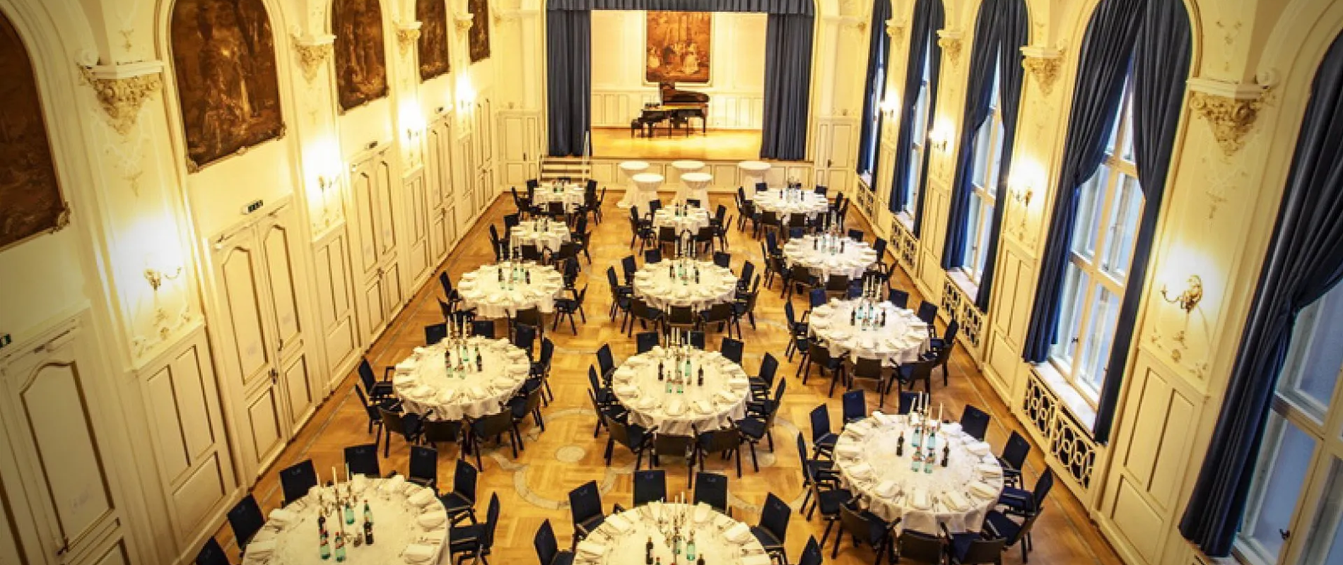 Festlich gedeckte runde Tische in einem eleganten Ballsaal für ein Corporate Event Frankfurt