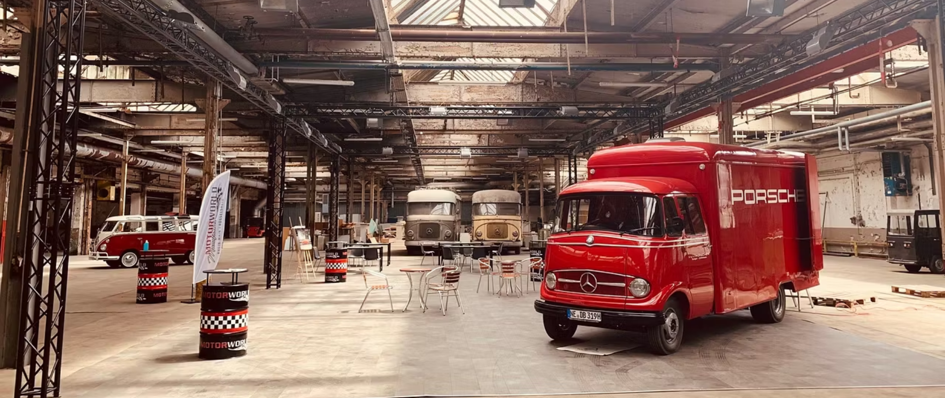 Roter Porsche-Transporter auf Mercedes-Basis bei einem Corporate Event Frankfurt in einer Industriehalle mit Oldtimern.