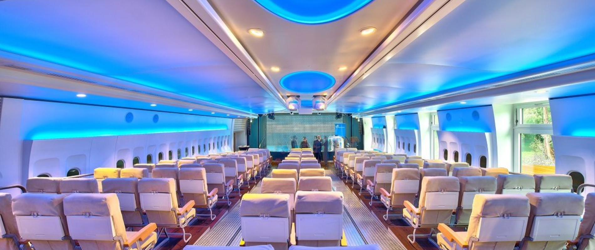 Umgebautes Flugzeug als exklusiver Eventraum für Corporate Events Frankfurt mit blauen Akzentlichtern und Bestuhlung.