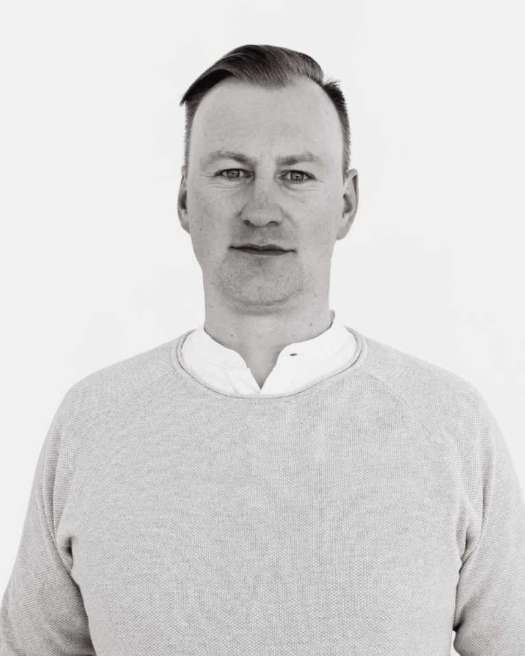 Mann im hellen Pullover – Teammitglied der Premium Eventagentur Frankfurt im professionellen Porträt.