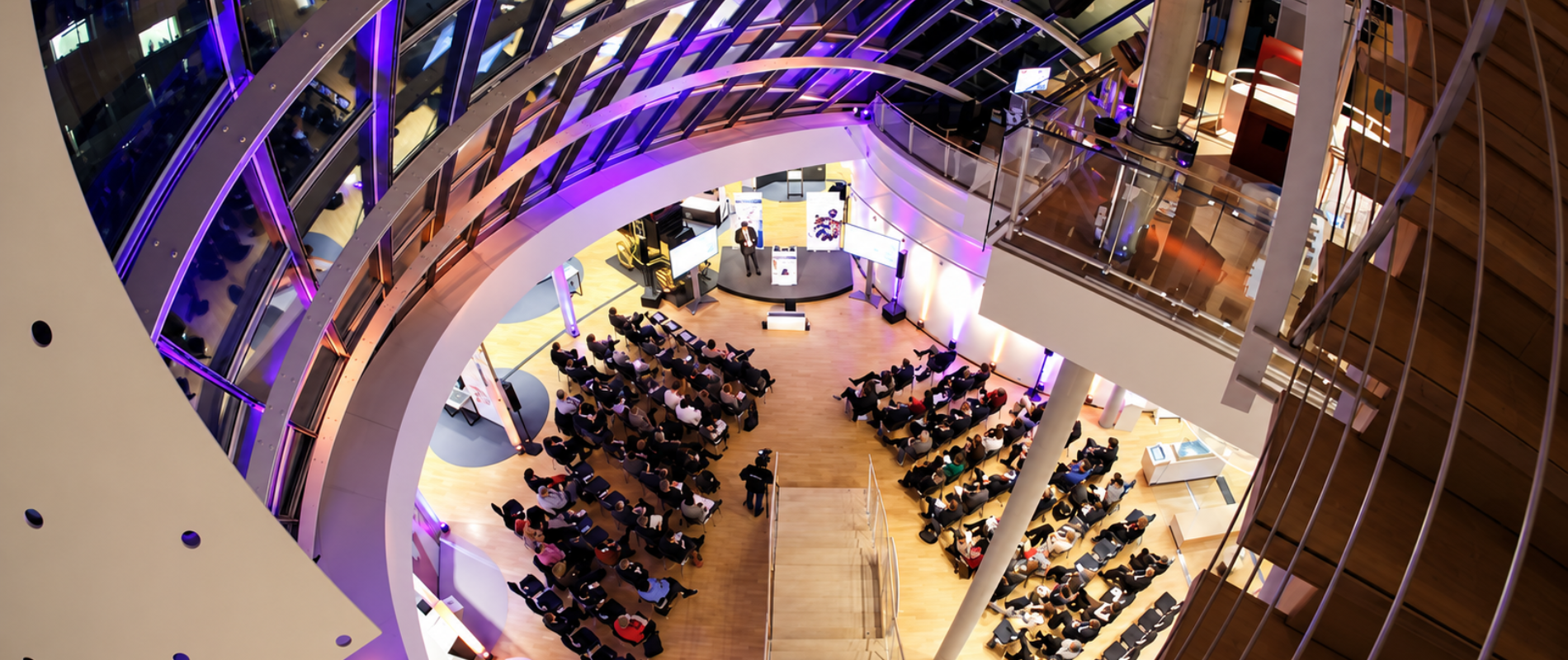 Modernes Konferenzzentrum beim Corporate Event Frankfurt mit Publikum, Bühne und stimmungsvoller Beleuchtung.