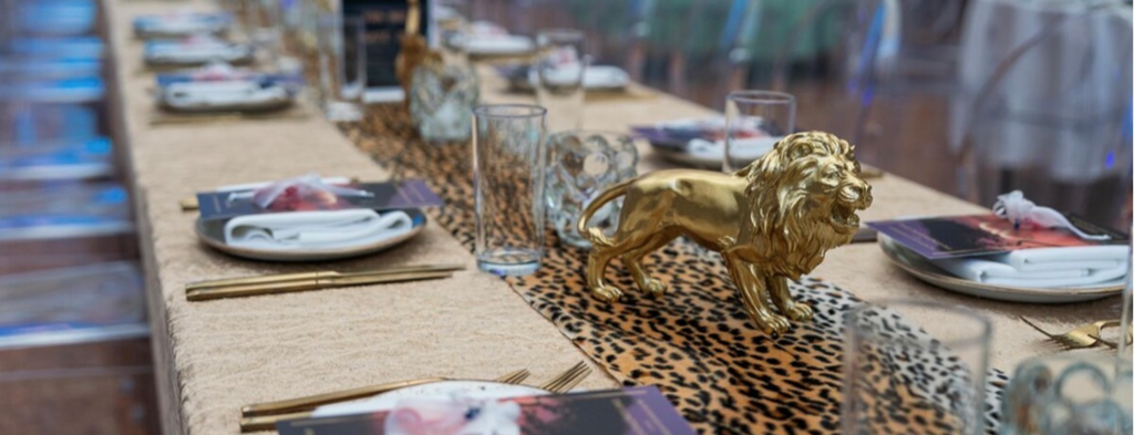 Festlich gedeckter Tisch mit goldener Löwenfigur, Leopardenmuster-Tischläufer und elegantem Catering Frankfurt Ambiente.