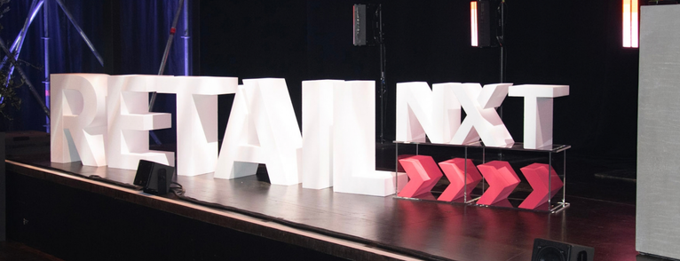 Leuchtende 3D-Buchstaben „Retail NXT" auf einer Bühne – inszeniert von einer Premium Eventagentur Frankfurt.